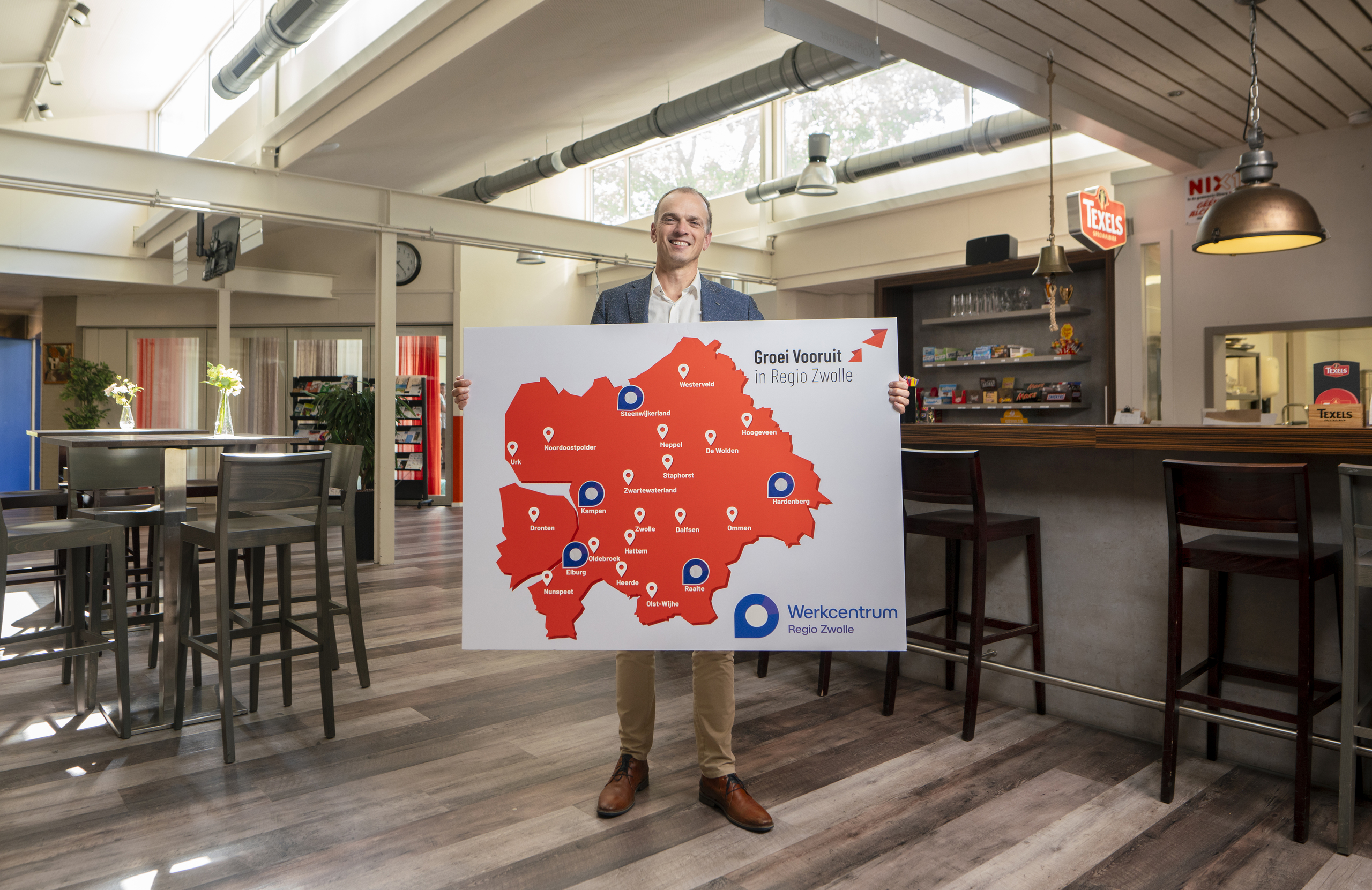Werkcentrum Zwolle opent inlooplocaties in de regio onder andere in de gemeente Elburg. Wethouder Anjo Simonse houdt een bord vast met alle inlooplocaties weergegeven