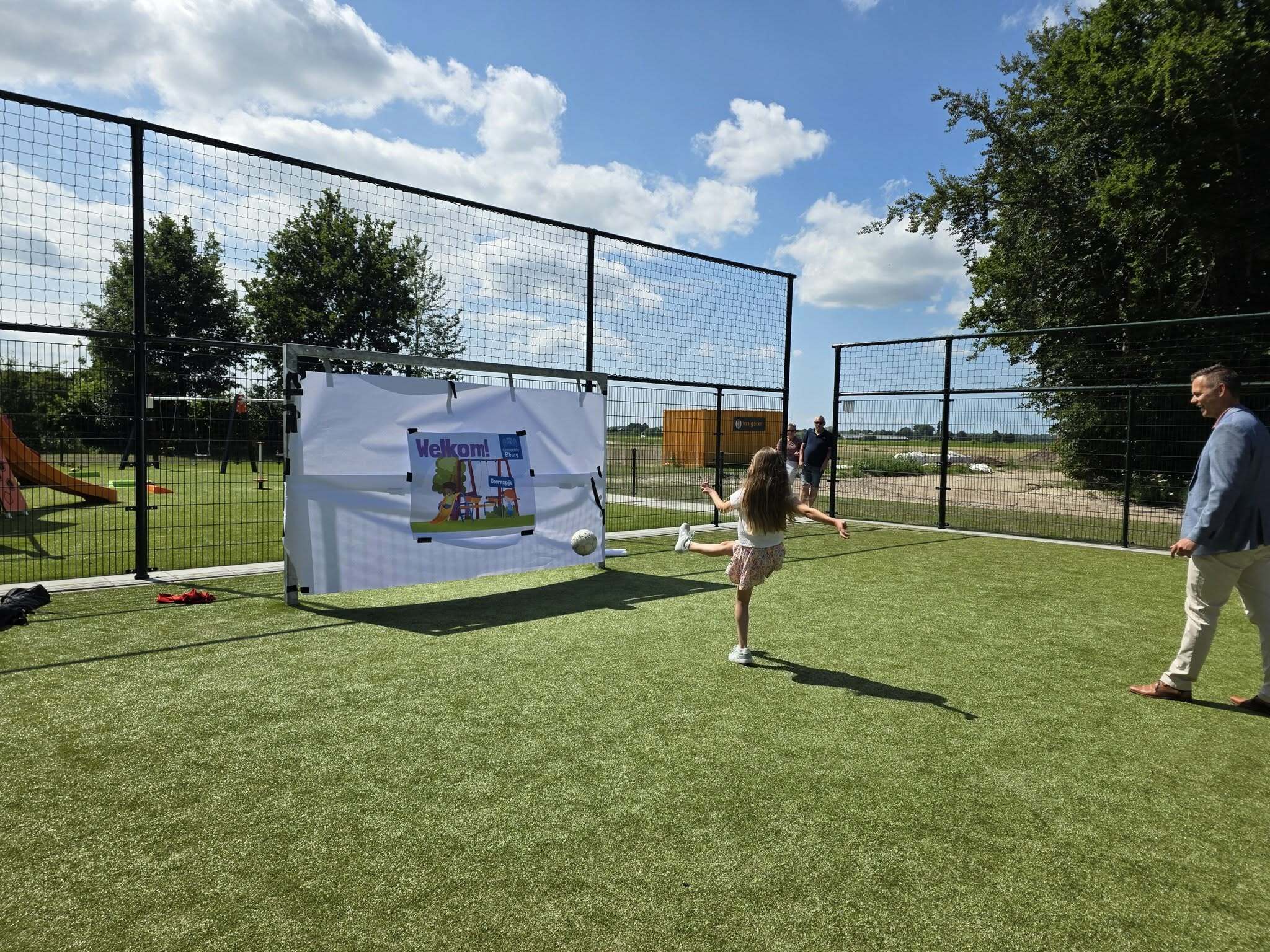 Opening speeltuin Beekenkampweg door wethouder Lennart Oosterloo en jeugdburgemeester Myra die een bal in het doel schiet