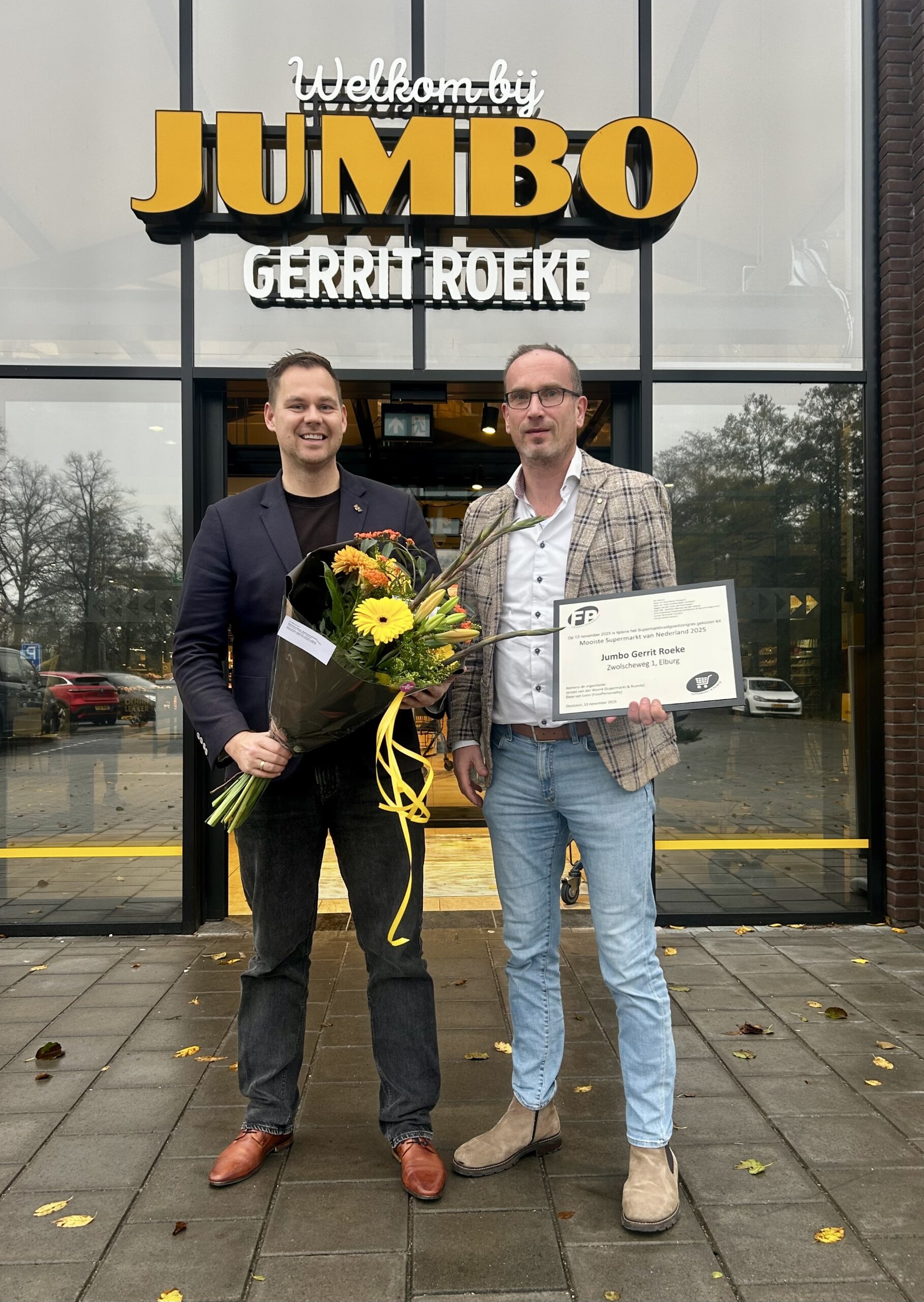 Wethouder Lennart Oosterloo overhandigd een bos bloemen aan Jumbo Gerrit Roeke