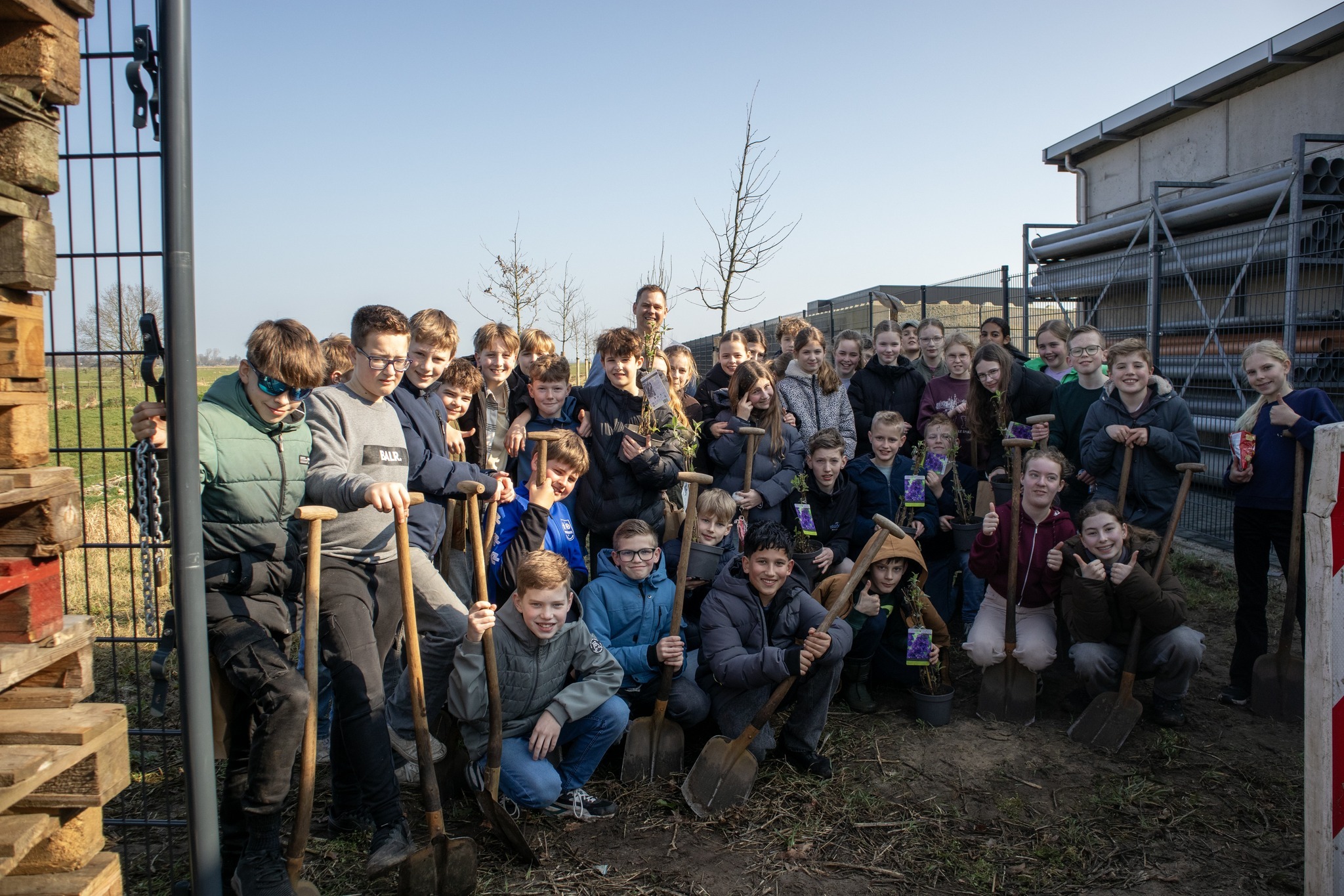 Groepsfoto van wethouder Lennart Oosterloo samen met de leerlingen van De Borchstee tijdens de Boomplantdag