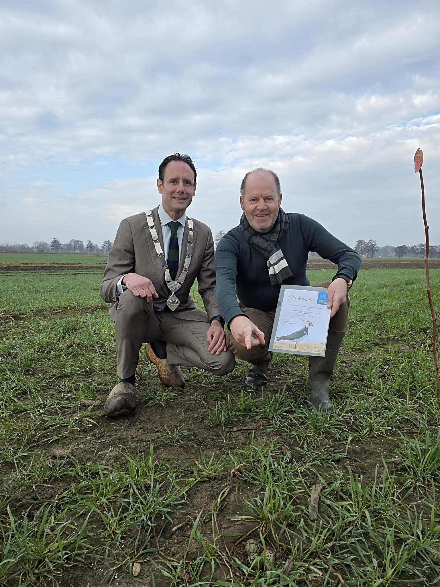 Burgemeester Harm-Jan van Schaik staat samen met Gijs van den Brink bij het 1e kievitsei dat door Gijs gevonden is in onze gemeente