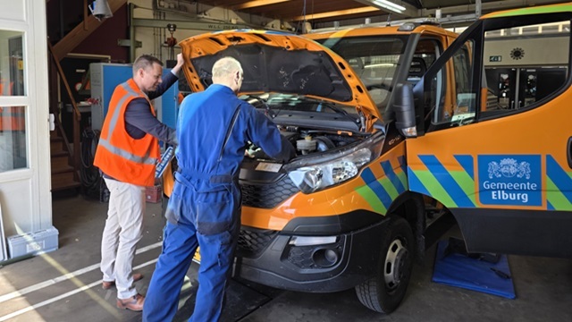 Wethouder Lennart Oosterloo kijkt mee bij het auto-onderhoud