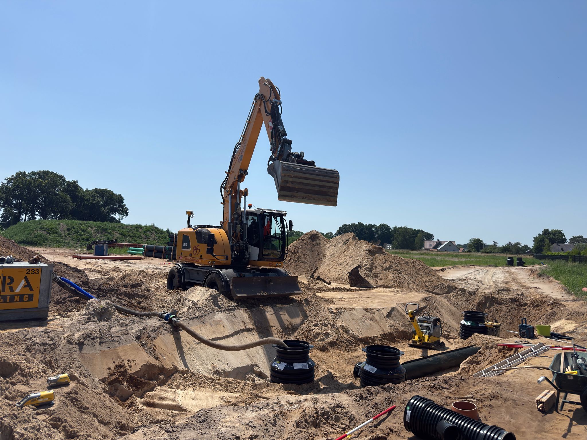 Een shovel is bezig met het bouwrijp maken van woningbouwplan Gerichtenweg Hoge Enk