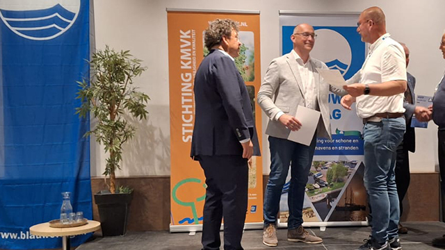 Havenmeester Henk Kroes neemt het certificaat Blauwe Vlag in ontvangst.