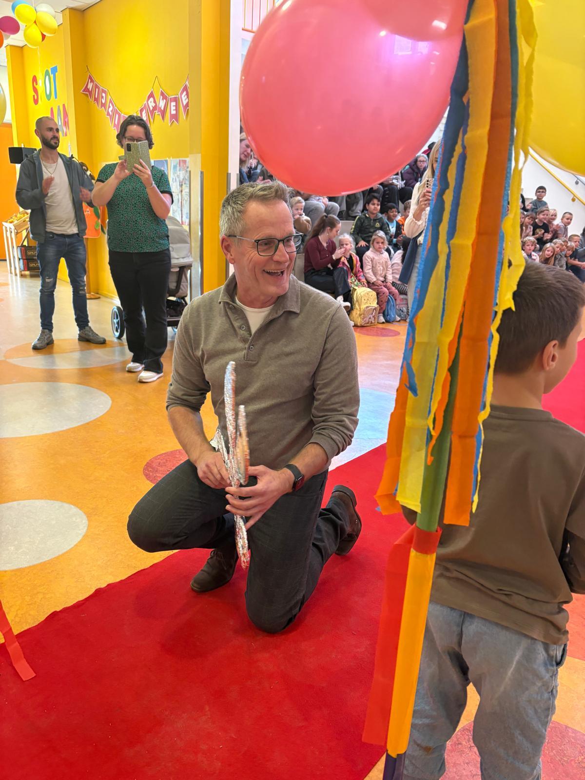De wethouder en Dorian knippen samen het lintje door.
