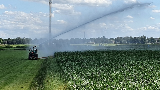 Met de trekker het land beregenen met water uit de sloot