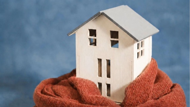 Een huis met een sjaal eromheen ter promotie voor de isolatieactie