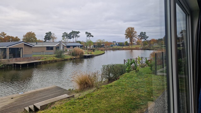 Vakantiepark, vanuit vakantiehuisje zicht op het water
