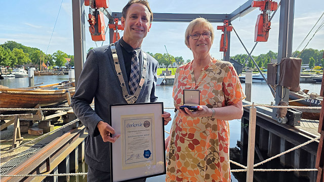 Lyda Sneevliet neemt erepenning in ontvangst van burgemeester Harm-Jan van Schaik 
